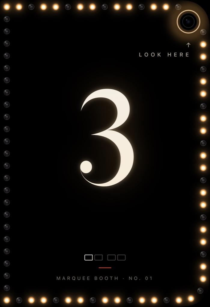 Marquee Booth on the outer display of iPhone Duo: the countdown at 3 inside a frame of marquee bulbs, with a Look here cue by the camera
